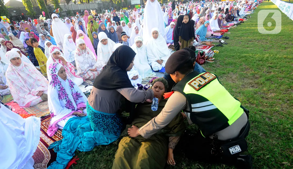 Petugas polisi memberikan minuma kepada jemaah perempuan itu. (merdeka.com/Arie Basuki)
