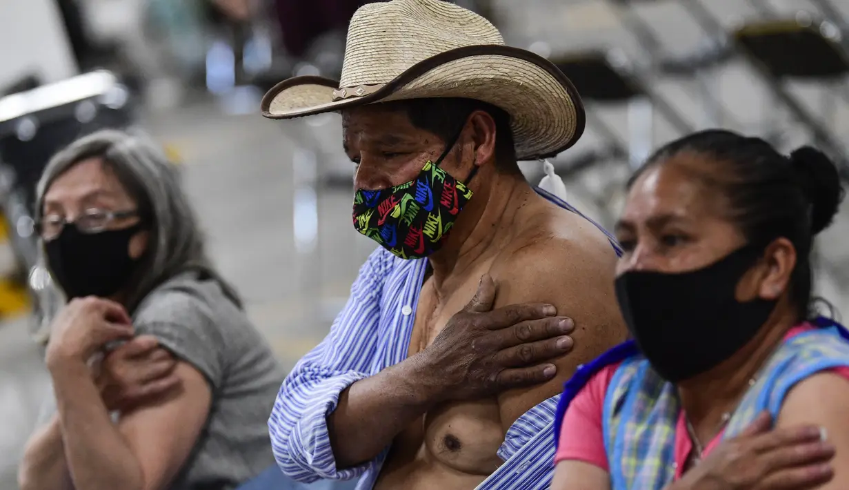 Orang-orang menunggu setelah disuntik dosis ketiga vaksin COVID-19 AstraZeneca di Centro de Estudios Superiores Navales (CENCIS) di Mexico City, Selasa (7/12/2021). Ibu kota Meksiko pada hari Selasa mulai memberikan vaksinasi booster untuk orang yang berusia di atas 60 tahun. (Pedro PARDO/AFP)