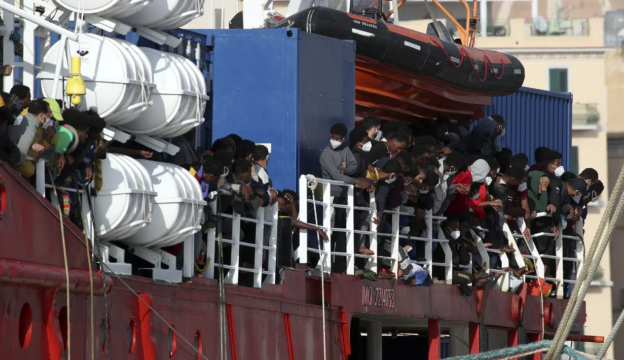 Migran berada di atas Kapal Sea Eye 4 saat tiba di Trapani, Sisilia, Italia, Minggu (7/11/2021). Kapal kemanusiaan Jerman diberikan izin oleh otoritas Italia setelah berhari-hari menunggu di Laut Mediterania. (Alberto Lo Bianco/LaPresse via AP)