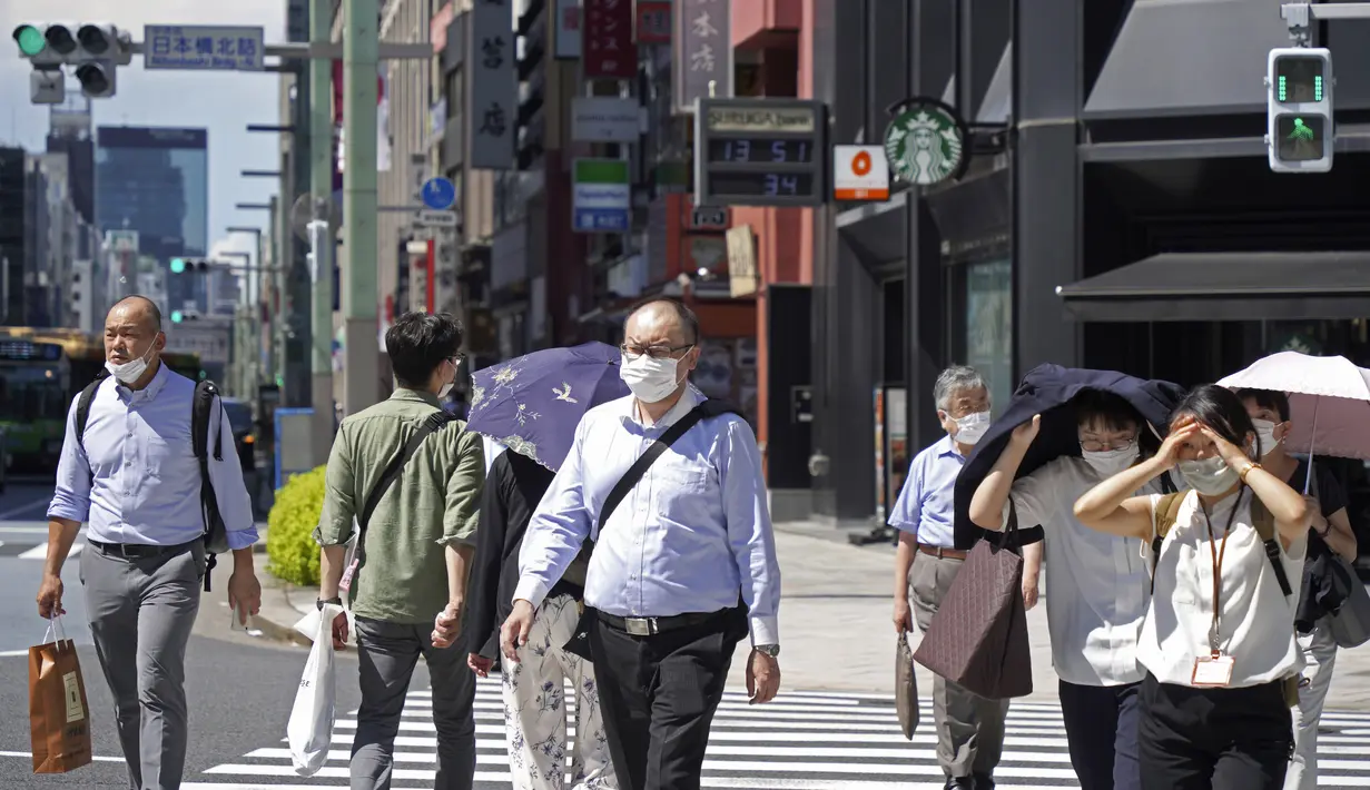 Orang-orang yang memakai masker melintasi persimpangan di Tokyo Kamis (5/8/2021). Meningkatnya kasus virus corona di sejumlah wilayah di Jepang, termasuk Tokyo, membuat pemerintah memperluas status darurat terbatas Covid-19 ke delapan prefektur. (AP Photo/Kantaro Komiya)