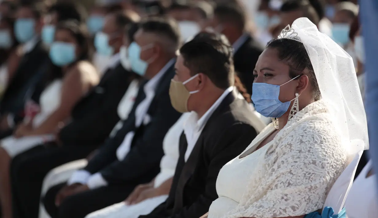 Pasangan pengantin duduk bersama saat pernikahan massal di Managua, Nikaragua, Minggu (14/2/2021). Sekitar 400 pasangan mengatakan "I do" pada Hari Valentine pada acara nikah massal gratis. (AP Photo/Diana Ulloa)