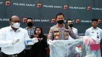 Kapolres Garut AKBP Wirdhanto Hadicaksono bersama Kasatreskrim Polres Garut AKP Dede Sopandi menunjukan barang bukti perbuatan rudakpaksa tersangka Asep, dalam rilis kasus di Mapolre Garut. (Liputan6.com/Jayadi Supriadin)