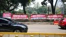 Kendaraan melintasi karangan bunga yang menghiasi kawasan Patung Kuda, Jakarta, Kamis (15/10/2020). Karangan bunga tersebut merupakan apresiasi masyarakat kepada TNI-Polri yang telah menjaga keamanan saat demo. (Liputan6.com/Faizal Fanani)