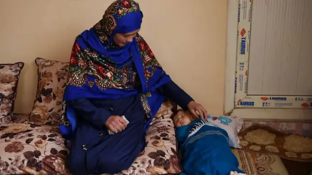 Wanita yang menggendong bayi saat ujian di Afganistan. (AFP)