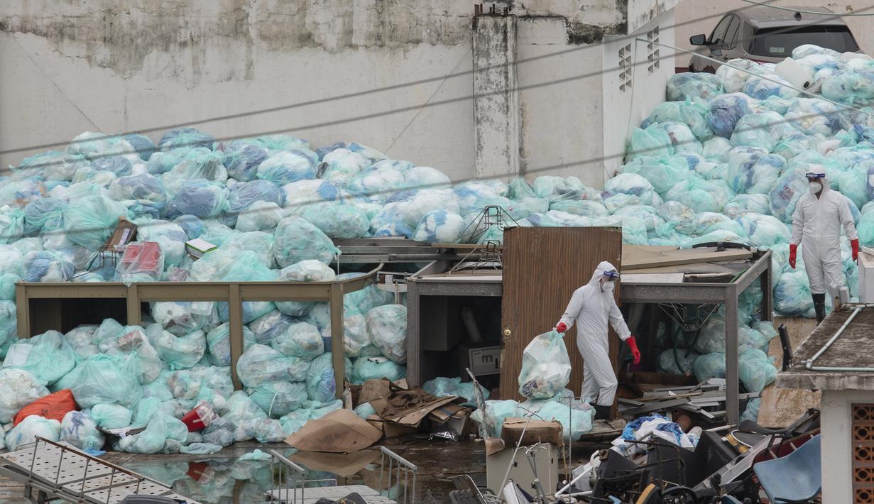 Petugas medis mengenakan alat pelindung diri saat membuang limbah biologis berbahaya di luar Rumah Sakit del Instituto Mexicano del Seguro Social, Veracruz, Meksiko, Rabu (12/8/2020). Pembuangan limbah medis yang tidak tepat menjadi masalah di tengah pandemi COVID-19. (AP Photo/Felix Marquez)