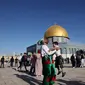 Umat Muslim merayakan setelah sholat Idul Fitri pagi, menandai akhir bulan suci Ramadhan, di luar masjid Kubah Batu di kompleks masjid Al-Aqsa di Yerusalem Tua (13/5/2021). (AFP/Ahmad Gharabli)