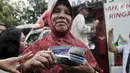 Warga seusai mengambil uang Kartu Lansia Jakarta (KLJ) melalui ATM Bank DKI di Jakarta Islamic Center, Koja, Rabu (24/4). Penerima KLJ mendapatkan Rp 600.000 per bulan sebagai bentuk pemberian bantuan sosial untuk pemenuhan kebutuhan dasar bagi lanjut usia. (merdeka.com/Iqbal S. Nugroho)