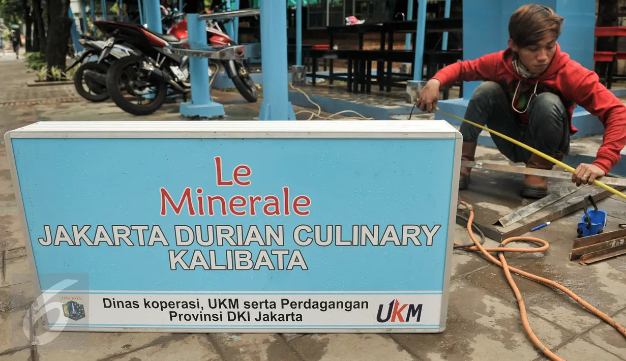 Pekerja menyelesaikan pengerjaan plang nama Pusat Penjualan Durian di Jalan TMP Kalibata, Jakarta Selatan, Kamis (9/2). Pemprov DKI Jakarta bangun Loksem Pusat Penjualan Durian di Kalibata. Liputan6.com/Yoppy Renato)