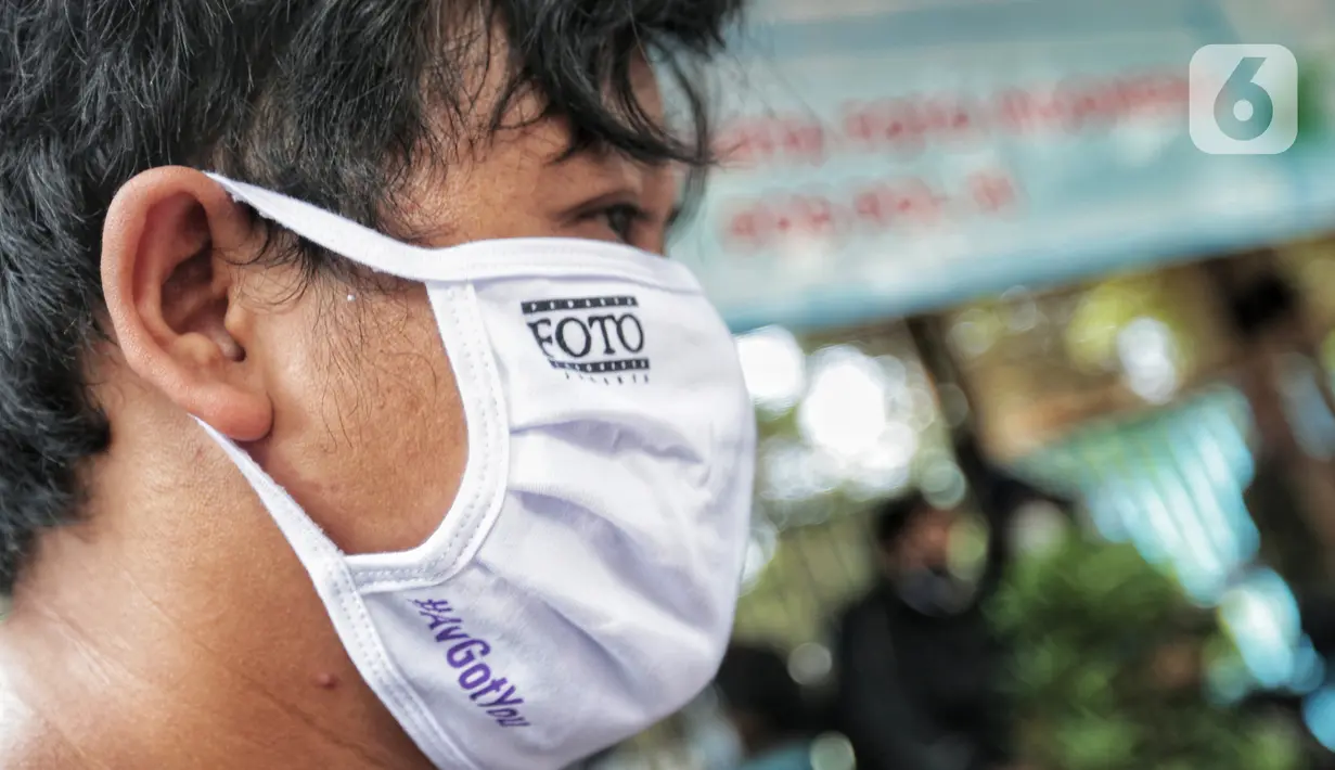 Anggota Pewarta Foto Indonesia Jakarta (PFIJ) memakai masker penunjang liputan di Jakarta, Rabu (22/4/2020). PFIJ membagikan 230 paket penunjang liputan berupa masker, hand sanitizer, dan multivitamin kepada anggotanya yang melaksanakan tugas jurnalistik selama pandemi. (Liputan6.com/Johan Tallo)