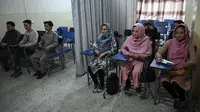 Mahasiswa dan mahasiswi menghadiri kelas yang dipisahkan dengan tirai di sebuah universitas swasta di Kabul, Afghanistan, Selasa (7/9/2021). Universitas di Afghanistan memisahkan pria dan wanita dalam kelas dengan tirai untuk mengikuti keputusan Taliban. (AAMIR QURESHI/AFP)