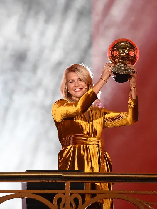 Bintang Lyon dan timnas Norwegia, Ada Hegerberg mengangkat trofi setelah memenangkan penghargaan Ballon d'Or perempuan 2018 di Paris, Senin (3/12). Hegerberg adalah salah satu dari tujuh pemain dari tim Lyon masuk di antara 15 nominasi. (FRANCK FIFE/AFP)