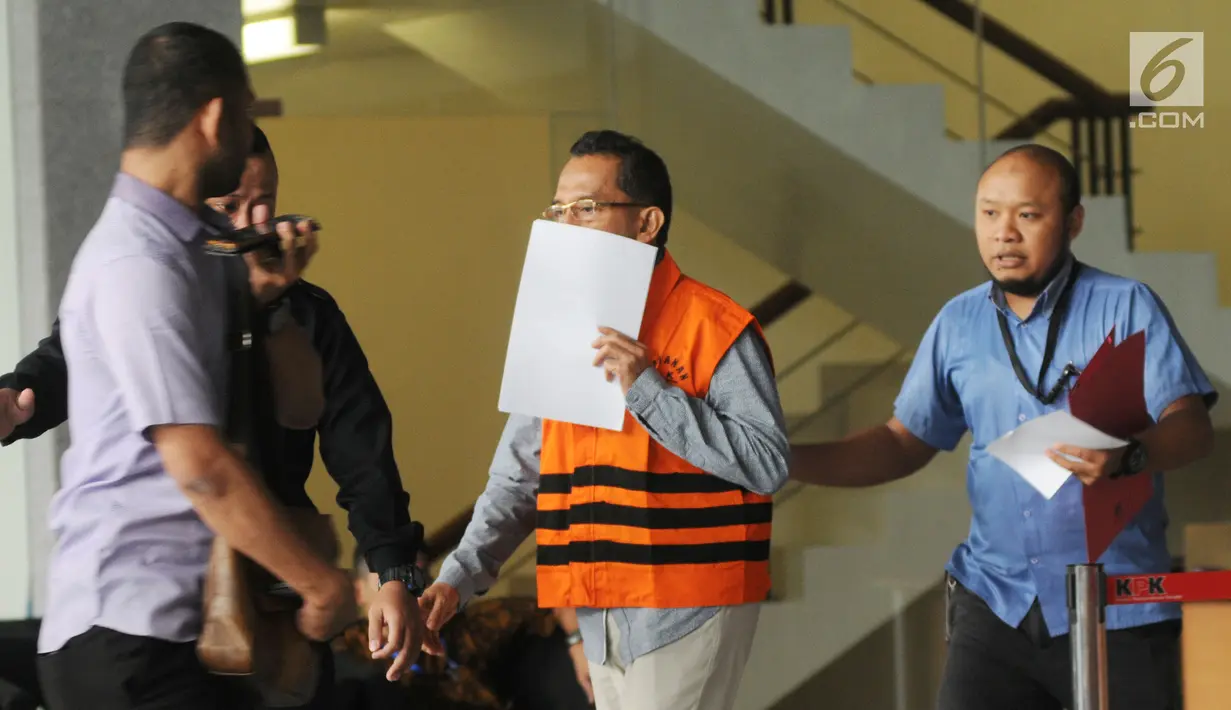 Anggota DPRD Sumatera Utara, Arifin Nainggolan (tengah) usai menjalani pemeriksaan di Gedung KPK, Jakarta, Senin (16/7). Arifin tampak menutupi wajahnya dengan kertas. (Merdeka.com/Dwi Narwoko)