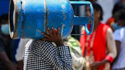 Warga membawa gas LPG di depan depo penjualan di tengah krisis ekonomi yang melanda di Kota Kolombo, Sri Lanka, Senin (23/5/2022). Pasokan gas terus menghadapi kekurangan akut, warga menunggu dalam antrean panjang untuk mendapatkan bahan bakar memasak. (AFP/ISHARA S. KODIKA)