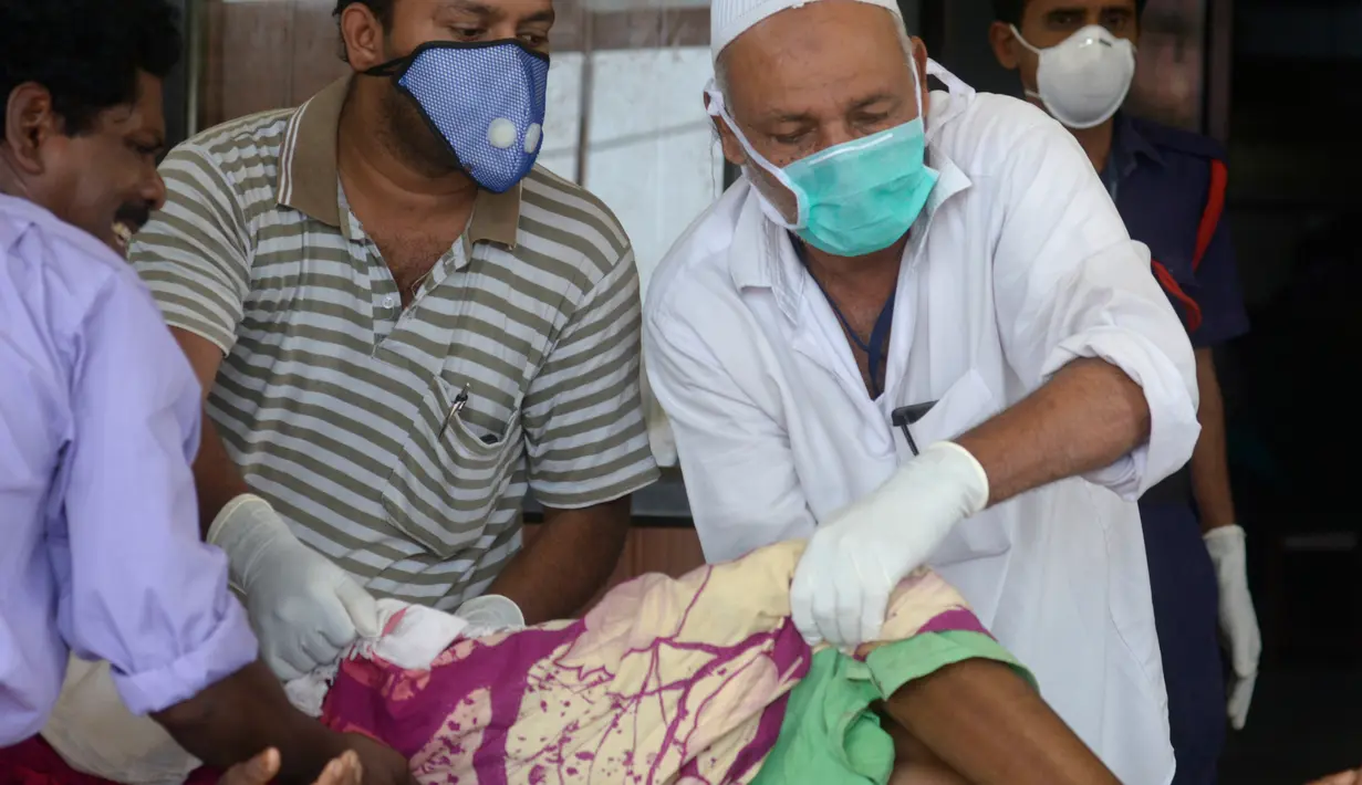Petugas memakai masker sebagai antisipasi penularan virus Nipah saat membantu pasien di RS Government Medical College, Kozhikode, Kerala, India Selatan, Kamis (24/5). Tidak ada vaksinasi untuk virus yang memiliki tingkat kematian 70 persen ini. (AP Photo)