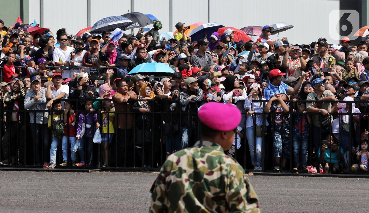 Antusiasme warga saat menyaksikan perayaan HUT ke-74 TNI di Lanud Halim Perdanakusuma, Jakarta Timur, Sabtu (5/10/2019). Warga rela panas-panasan dan berdesak-desakan untuk menyaksikan perayaan HUT ke-74 TNI. (Liputan6.com/JohanTallo)