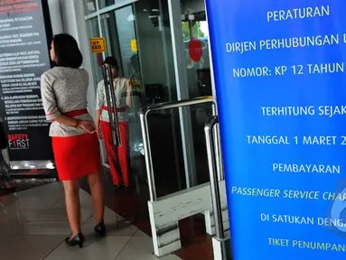 Sebuah standing banner yang berisi pengumuman dari Dirjen Perhubungan Udara terpampang di depan pintu masuk keberangkatan Bandara Soekarno-Hatta, Jakarta, Sabtu (28/2/2015).(Liputan6.com/Faisal R Syam)