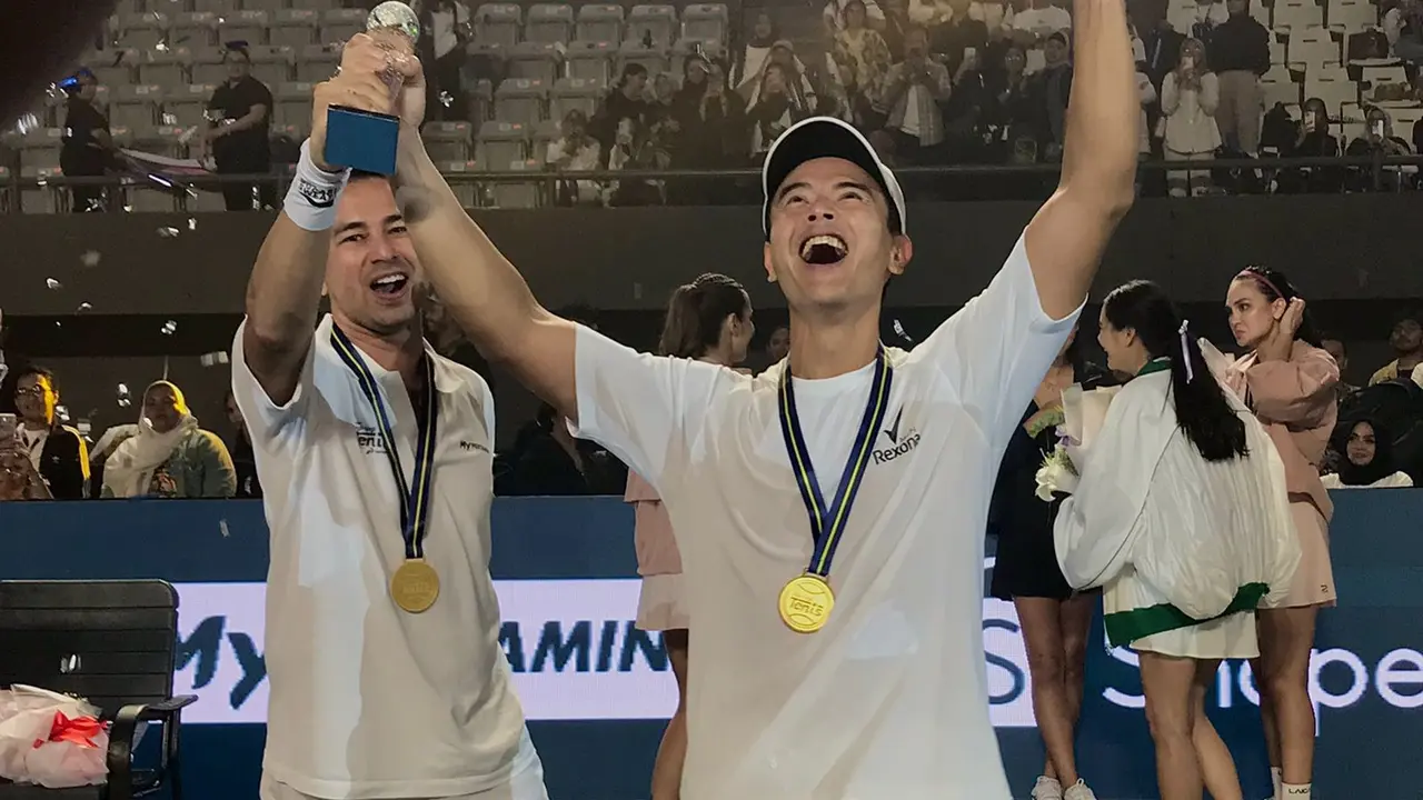 Raffi Ahmad dan Dion Wiyoko mengangkat piala kemenangan di acara Lagi-Lagi Tenis,