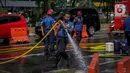 Personil pemadam kebakaran membersihkan tumpah oli di Jalan Veteran depan Gedung Krida Bakti, Jakarta, Kamis (16/1/2020). Sudin Damkar Jakarta Pusat mengerahkan 2 unit mobil damkar dan 10 personil untuk membantu pembersihan bagian jalan yang terkena tumpahan oli. (Liputan6.com/Faizal Fanani)