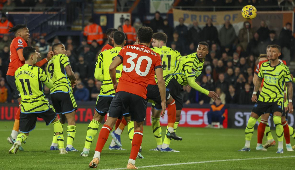 Bek Luton Town, Gabriel Osho (kiri) melepaskan sundulan ke gawang Arsenal yang berbuah gol penyeimbang 1-1 pada laga lanjutan pekan ke-15 Liga Inggris 2023/2024 di Kenilworth Road, Luton, Rabu (6/12/2023) dini hari WIB. (AP Photo/Ian Walton)