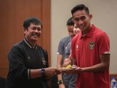 Pelatih Kepala Timnas Indonesia U-22, Indra Sjafri (kiri) memberikan potongan tumpeng terhadap Kapten Timnas Indonesia U-22, Rizky Ridho saat syukuran terkait sanksi ringan FIFA terhadap Indonesia dan kesempatan Timnas Indonesia U-22 tampil di SEA Games 2023 di Ruang Semeru, Hotel Sultan, Jakarta. (Bola.com/Bagaskara Lazuardi)