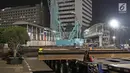 Petugas menggunakan alat berat merobohkan Jembatan Penyeberangan Orang (JPO) di Kawasan Bundaran Hotel Indonesia (HI), Jakarta, Senin (30/7/2018) malam. JPO dirobohkan karena menghalangi pandangan ke patung Selamat Datang. (Liputan6.com/Herman Zakharia)