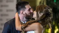 Bintang Barcelona, Lionel Messi, mencium bibir sang istri, Antonella Roccuzzo, dihadapan wartawan usai mengadakan resepsi pernikahan di Kompleks City Center, Santa Fe, Jumat (30/6/2017). (AFP/Eitan Abramovich)