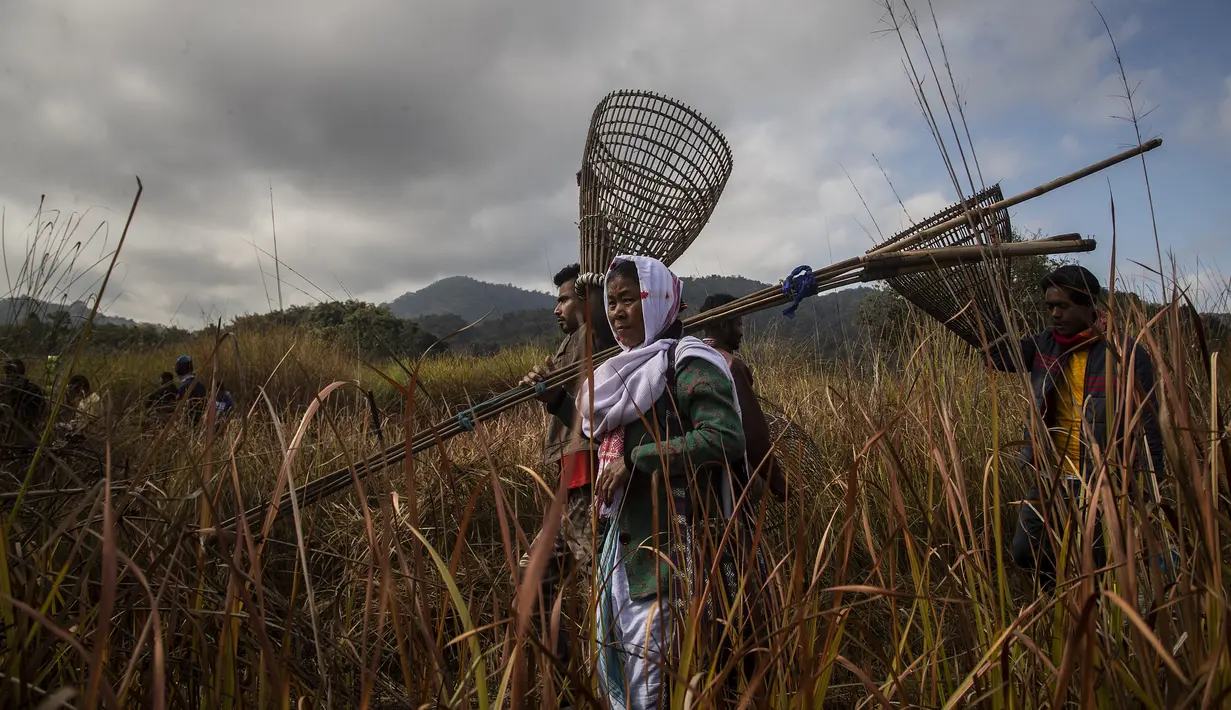 Penduduk desa tiba membawa peralatan memancing untuk mencari ikan sebagai bagian dari perayaan Bhogali Bihu di desa Panbari, sekitar 50 km timur Gauhati, India, Kamis (13/1/2022). "Bhogali Bihu" menandai berakhirnya musim panen di timur laut negara bagian Assam. (AP Photo/Anupam Nath)
