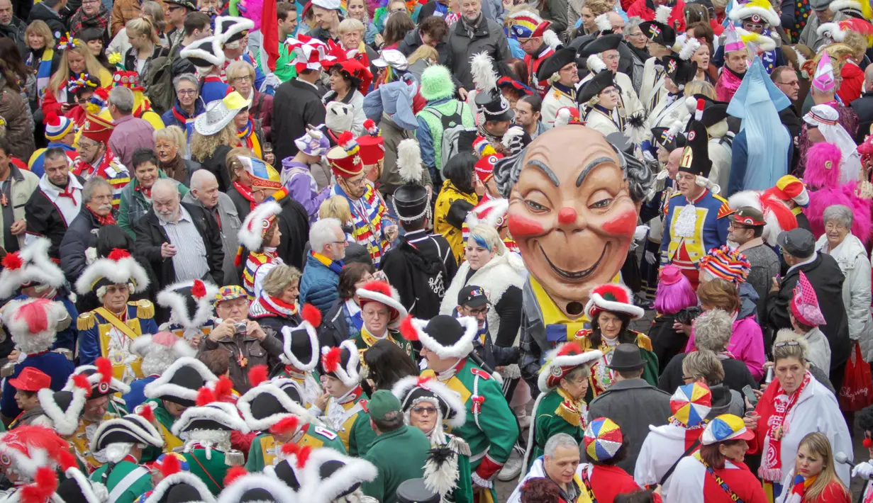 Ribuan peserta mengikuti karnaval yang dinamakan karnaval bodoh di Mainz, Jerman, Rabu (11/11/2015). Mereka akan menyerbu kota - kota wilayah Rhine yang menjadi tujuan utama karnaval. (AFP PHOTO/Fredrik VON Erichsen)