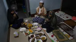 Sebuah keluarga Muslim Thailand berdoa sebelum berbuka puasa di ruang tamu rumah mereka di Bangkok, pada 28 April 2020. Banyak tempat ibadah ditutup guna membendung penyebaran Virus Corona COVID-19 ketika Umat Muslim di seluruh dunia menyambut bulan suci Ramadan. (AP Photo/Gemunu Amarasinghe)