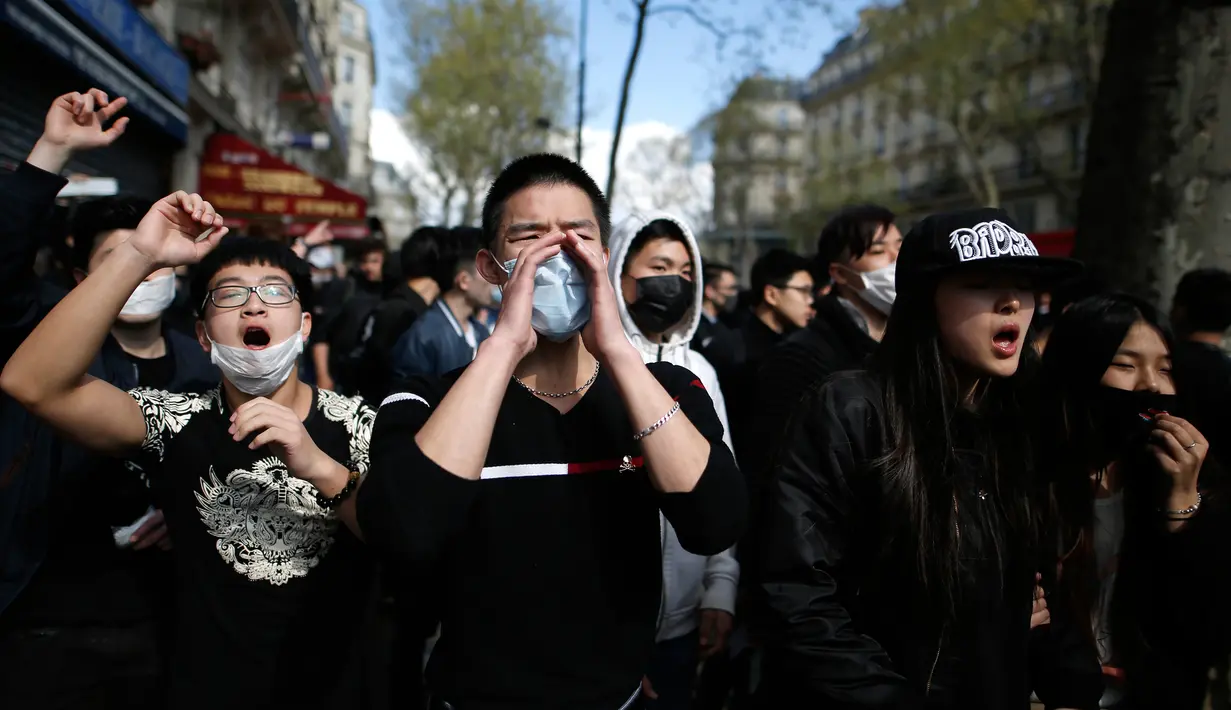 Demonstran bersorak-sorak saat menggelar aksinya di Place de la Republique, di Paris, Prancis (2/4). Sejumlah demonstran dilaporkan melemparkan botol, telur, dan buah kepada aparat yang berusaha mencegah aksi mereka. (AFP/Benjamin Cremel)