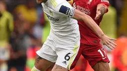 Pemain Leeds United Liam Cooper (kiri) berebut bola dengan pemain Liverpool Mohamed Salah (kanan) pada pertandingan Liga Inggris di Elland Road, Leeds, Inggris, 12 September 2021. Liverpool menang 3-0. (Oli SCARFF/AFP)