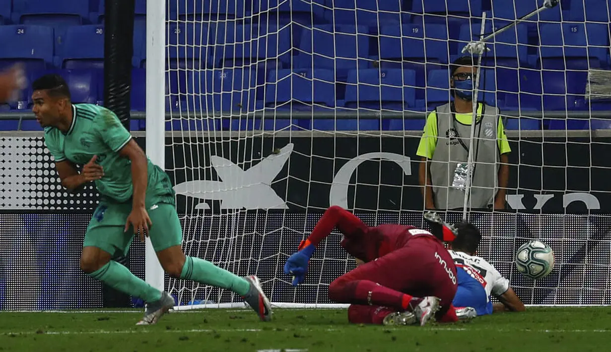 Gelandang Real Madrid, Casemiro, mencetak gol ke gawang Espanyol pada laga La Liga di Stadion Cornella-El Prat, Minggu (28/6/2020). Real Madrid menang 1-0 atas Espanyol. (AP/Joan Monfort)
