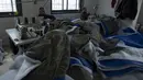 Penjahit memproduksi dan menyiapkan pengiriman massal perlengkapan tidur untuk korban gempa bumi di Turki dan Suriah yang sekarang terkena cuaca musim dingin yang membekukan, di sebuah pabrik Palestina di kota Hebron, Tepi Barat, Kamis (16/2/2023). Warga Palestina telah turun tangan untuk membantu mereka yang terguncang akibat gempa dahsyat di Turki dan Suriah, dengan Otoritas Palestina bahkan mengirim tim medis dan ahli lainnya untuk mendukung upaya penyelamatan. (AP Photo/Nasser Nasser)