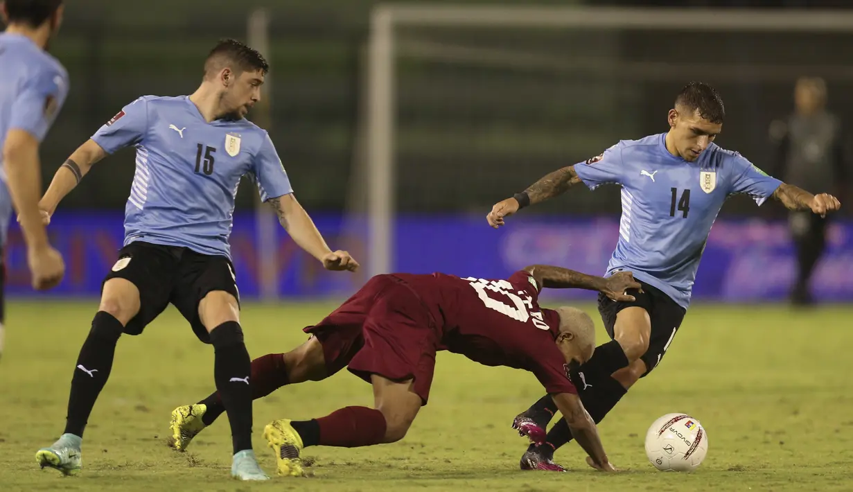Gelandang timnas Venezuela, Romulo Otero bersaing dengan pemain Uruguay, Federico Valverde dan Lucas Torreira dalam lanjutan kualifikasi Piala Dunia 2022 di Stadion Olimpico de la UCV, Caracas, Rabu (9/6/2021) pagi WIB. Uruguay ditahan imbang tanpa gol oleh Venezuela. (Manaure Quintero, Pool via AP)