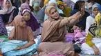 Seorang perempuan berswafoto sebelum sholat Idul Adha di sebuah jalan di Jakarta, Indonesia, Kamis, 29 Juni 2023. (AP Photo/Tatan Syuflana)