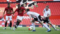 Penyerang Manchester United, Anthony Martial, mencetak gol ke gawang Sheffield United pada laga Premier League di Stadion Old Trafford, Rabu (24/6/2020). Manchester United menang dengan skor 3-0. (AP/Michael Regan)