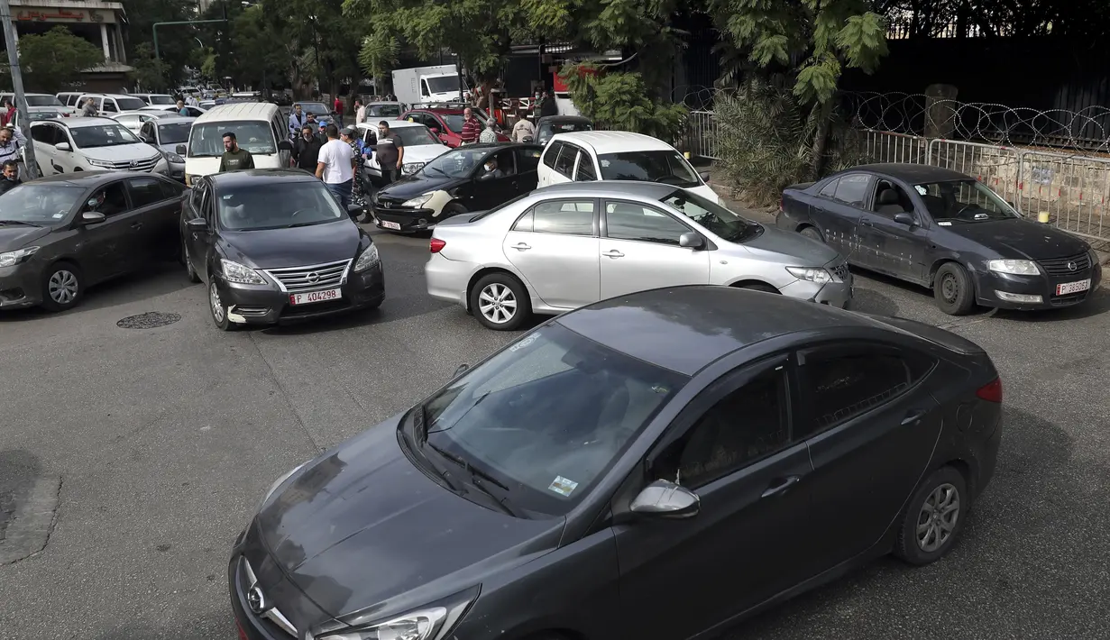 Pengemudi taksi memblokir jalan dengan kendaraan mereka selama aksi protes di depan kementerian dalam negeri, di Beirut, Lebanon, Selasa (30/11/2021). Mereka memprotes kenaikan harga bensin, barang-barang konsumsi dan jatuhnya mata uang pound Lebanon. (AP Photo/Bilal Hussein)