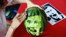 Seorang siswa sekolah menengah mengukir wajah pemain sepak bola Polandia, Robert Lewandowski pada buah semangka di Shenyang, Provinsi Liaoning, China, Senin (9/7). (AFP)