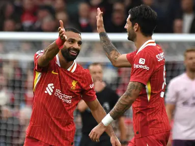 Pemain Liverpool, Mohamed Salah (kiri) melakukan selebrasi dengan Dominik Szoboszlai setelah mencetak gol kedua timnya selama pertandingan Liga Premier Inggris melawan Brentford di Stadion Anfield, Liverpool, Minggu, 25 Agustus 2024. (AP Photo/Rui Vieira)