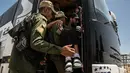 Seorang lelaki cacat dibantu naik ke bus ketika keluarga militan ISIS meninggalkan kamp penampungan al-Hol di Provinsi Hasakeh, Suriah, Senin (3/6/2019). Keluarga militan ISIS ini dibebaskan untuk diserahkan kepada para tetua suku Arab dari daerah sekitar Raqqa. (AP Photo/Baderkhan Ahmad)