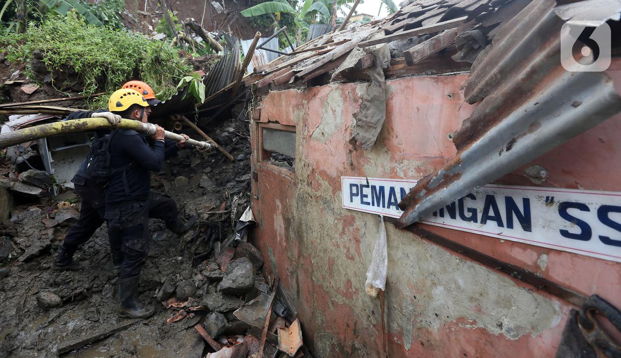 Petugas membersihkan material longsor pada areal pemancingan yang menyebabkan satu orang meninggal dunia di Gang Kepatihan, Kelurahan Kebon Kelapa, Kecamatan Bogor Tengah, Bogor, Jawa Barat, Rabu (12/10/2022). Longsor yang terjadi pada kemarin sore menyebabkan sembilan pemancing tertimbun tanah namun selamat dan seorang anggota kepolisian meninggal. (merdeka.com/Arie Basuki)