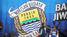 Pendukung Persib berjalan di samping Bus Bandung Tour on Bus (Bandros) yang akan mengangkut para pemain Persib Bandung dalam Pawai Persib Juara Piala Presiden di Kota Baru Parahyangan, Bandung, Minggu (25/10/2015). (Bola.com/Nick Hanoatubun)