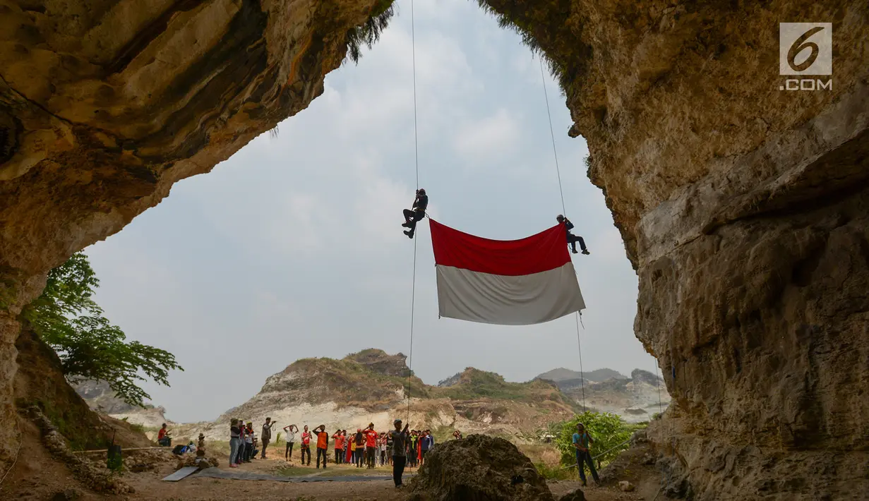 Pegiat alam bebas dan Kelompok Pecinta Lingkungan Gembala mengibarkan bendera merah putih pada HUT ke-74 RI di lokasi bekas tambang Tebing Arpam, Guha Tugu Gula, Klapanunggal, Kabupaten Bogor, Sabtu (17/8/2019). Upacara tersebut sebagai bentuk pelestarian kawasan karts. (merdeka.com/Imam Bukhori)