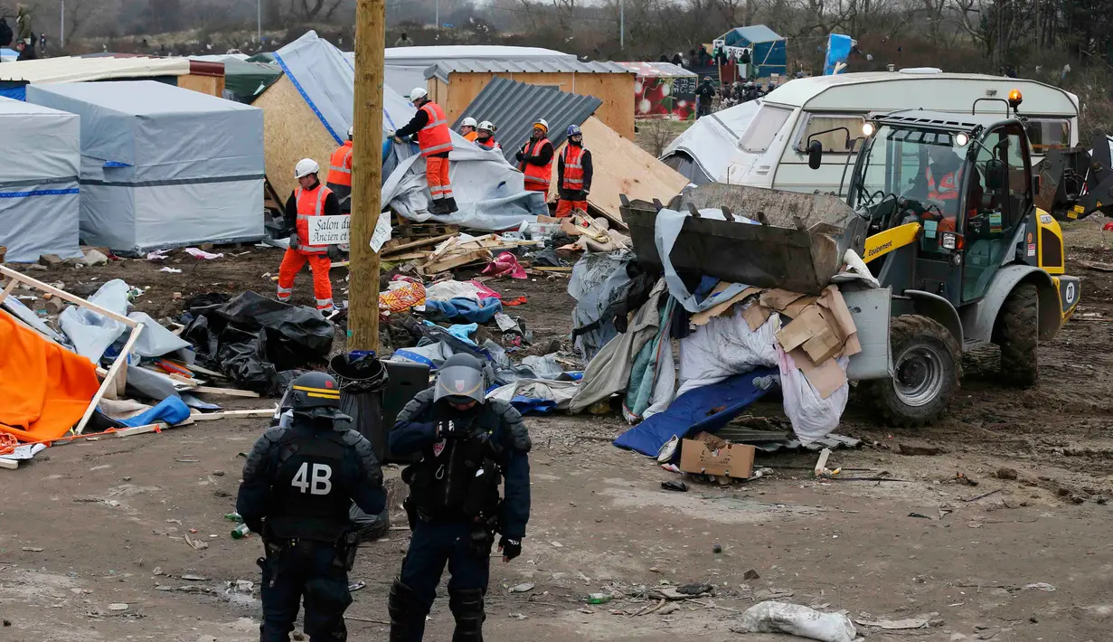 Alat berat saat merobohkan kamp pengungsian di lahan kumuh yang dijuluki "Jungle" di Calais, Prancis (1/3). Kamp ini berpenghuni sekitar 3.000 pengungsi dan pencari suaka. (REUTERS/Pascal Rossignol)