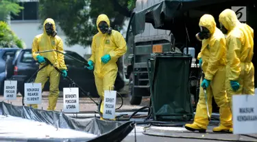 Tim Pasukan Gerak Cepat (PGC) melakukan sterilisasi sebuah mobil yang kedapatan positif terjangkit pandemi influenza H7N9 saat simulasi penanganan Episenter Pandemi Influenza di Puspiptek Tangerang Selatan, Rabu (20/9). (Liputan6.com/Helmi Afandi)