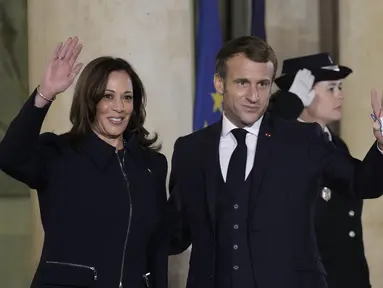 Presiden Prancis Emmanuel Macron dan Wakil Presiden AS, Kamala Harris melambaikan tangan menjelang pertemuan di Istana Elysee, Rabu (10/11/2021). Kamala Harris bertemu dengan Macron dalam upaya untuk meredakan ketegangan terkait kesepakatan kapal selam yang dibatalkan. (Ludovic MARIN/AFP)