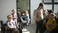 Anak-anak pengungsi dari Ukraina menunggu dengan ibu mereka untuk memulai kelas mereka di Berlin, Jerman, Senin (21/3/2022). Kedua kelas privat pengungsi tersebut disatukan oleh dua relawan Berlin yang berhasil menggalang dana dan mendapatkan ruang kelas gratis. (AP Photo/Markus Schreiber)