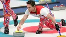 Atlet curling Norwegia, Thomas Ulsrud tampil bertanding melawan Amerika Serikat pada perhelatan Olimpiade Musim Dingin Pyeongchang 2018, Minggu (18/2). Atlet curling tersebut mengenakan celana merah bergambar bunga biru dan putih. (AP/Aaron Favila)