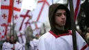 Peserta "Alilo" memegang bendera selama mengikuti pawai bersama di jalanan Tbilisi, Georgia, Kamis (7/1). Para peserta ini merupakan penganut Kristen Ortodoks di Georgia. (REUTERS/David Mdzinarishvili)