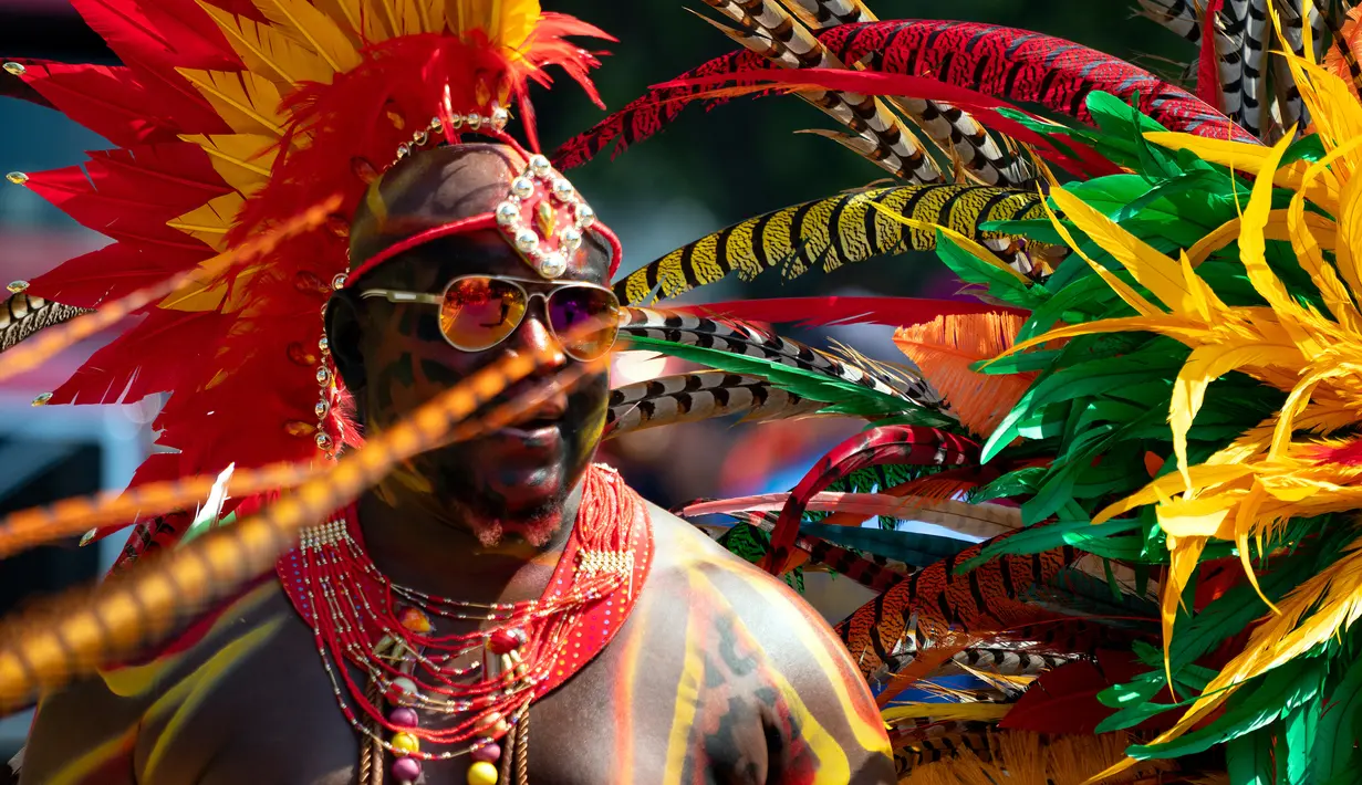 Seorang peserta mengenakan kostum saat berpartisipasi dalam Parade West Indian Day di distrik Brooklyn, New York, Senin (3/9).  Parade untuk memperingati budaya dan sejarah Karibia tersebut digelar rutin setiap tahun. (AP Photo/Craig Ruttle)